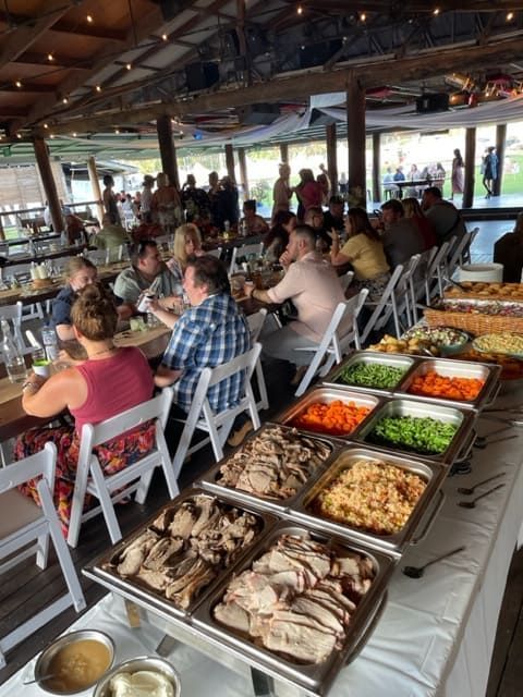 A Group Of People Are Sitting At Tables Eating Food From A Buffet — Tru Blu Catering In Kempsey, NSW