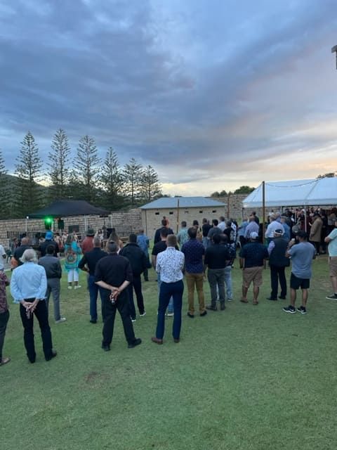 A Group Of People Are Standing In A Grassy Field In Front Of A Tent — Tru Blu Catering In Port Macquarie, NSW