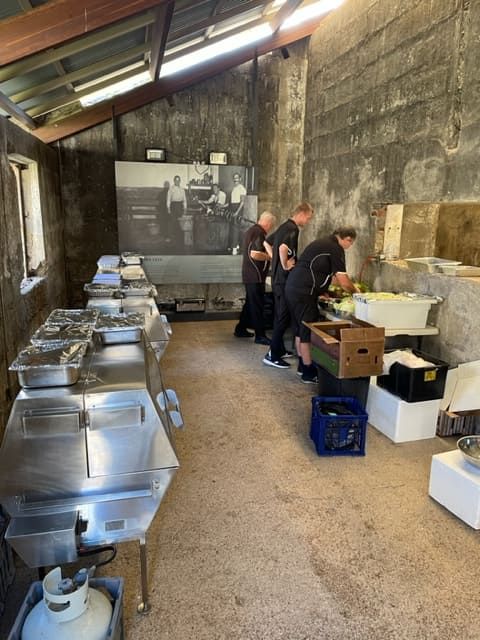 People Are Working In A Kitchen With A Large Picture On The Wall Behind Them — Tru Blu Catering In Port Macquarie, NSW