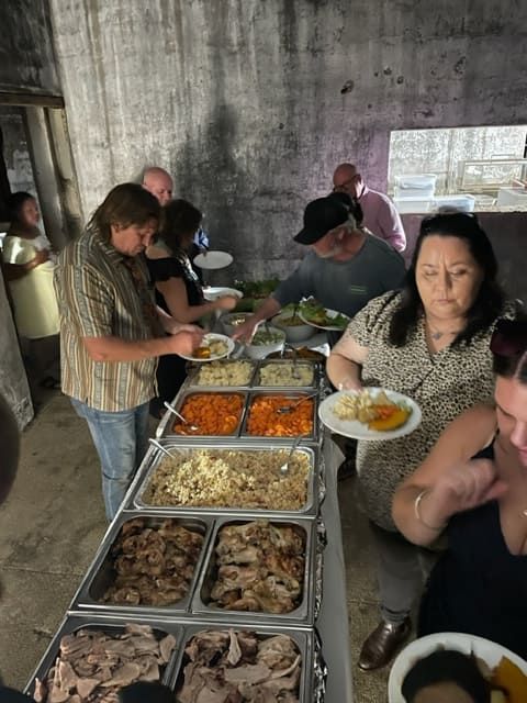 A Group Of People Are Eating Food From A Buffet Table — Tru Blu Catering In Port Macquarie, NSW