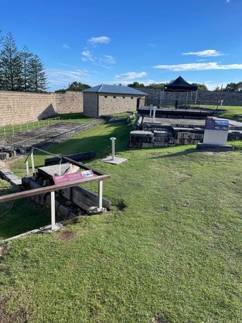 A Large Grassy Field With A Stone Wall In The Background — Tru Blu Catering In Port Macquarie, NSW