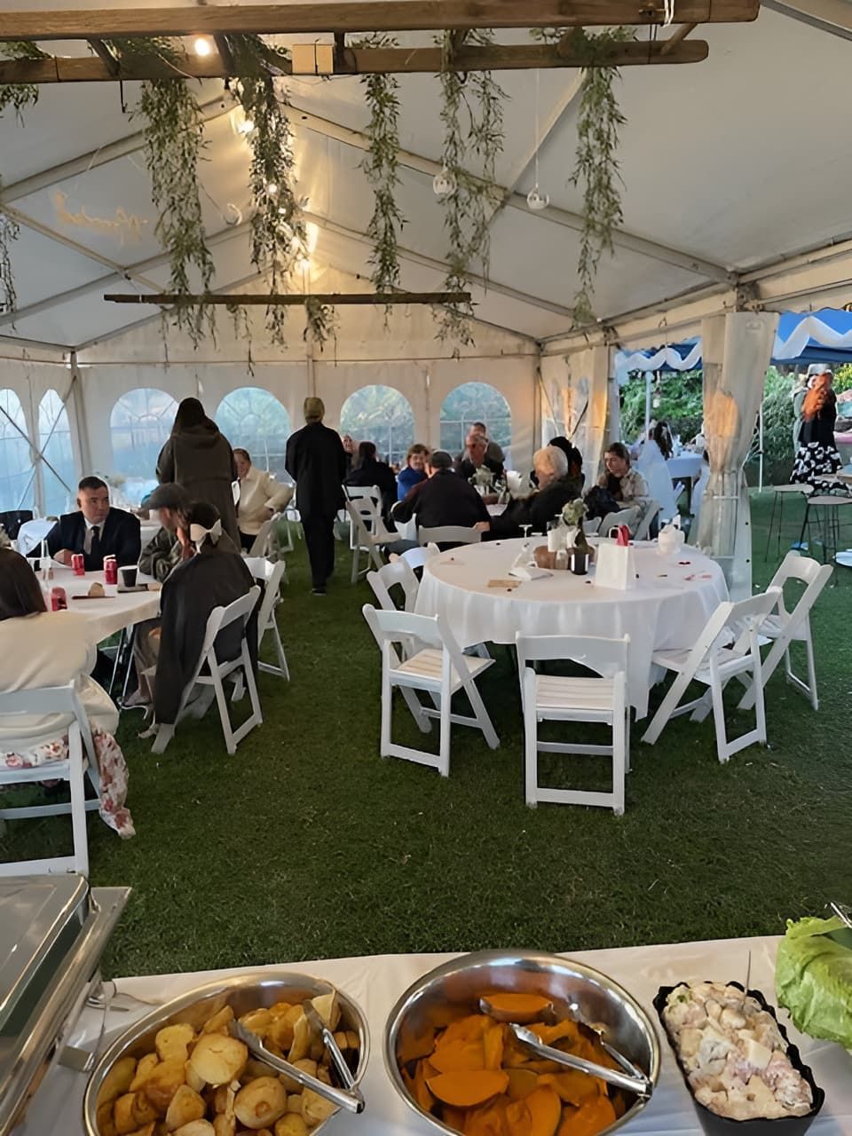 A Group Of People Are Sitting At Tables Under A Tent — Tru Blu Catering In Lake Cathie, NSW