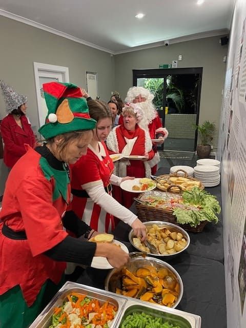 A Group Of People Dressed As Elves Are Serving Food To Santa Claus โ Tru Blu Catering In Port Macquarie, NSW