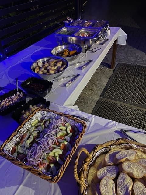 A Buffet Table With Bowls Of Food And Baskets Of Bread โ Tru Blu Catering In Port Macquarie, NSW