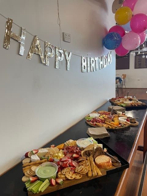 A Table With Plates Of Food And A Banner That Says Happy Birthday — Tru Blu Catering In Port Macquarie, NSW