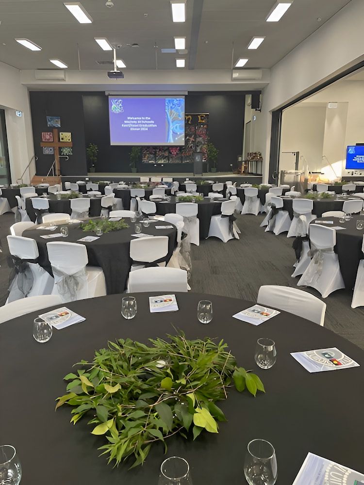 A Large Room Filled With Tables And Chairs And A Projector Screen โ Tru Blu Catering In Port Macquarie, NSW