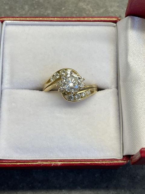Diamond ring in a red jewelry box with a white cushioned interior