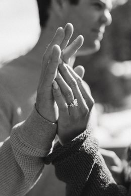 Two hands pressed together in a high-five, with a blurred person in the background.