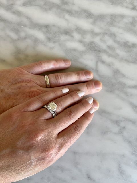 Hands with wedding rings on a marble surface