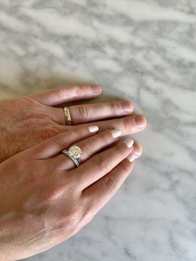 Hands with wedding rings on a marble surface