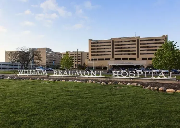 William Beaumont Hospital sign in front of a large beige hospital building and green lawn
