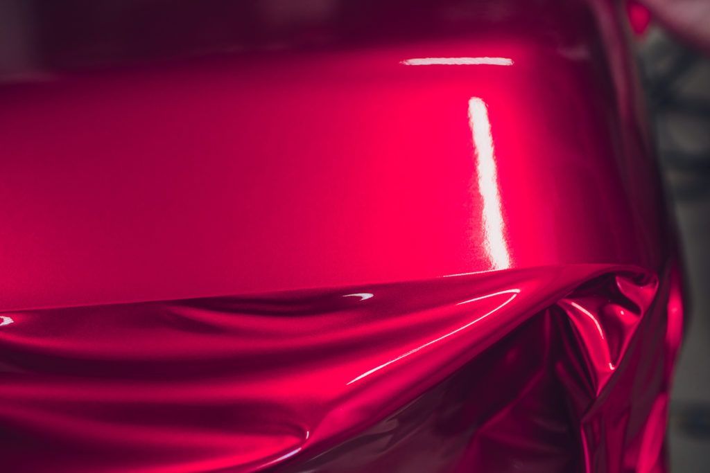 Close-up of glossy metallic pink fabric with reflective folds