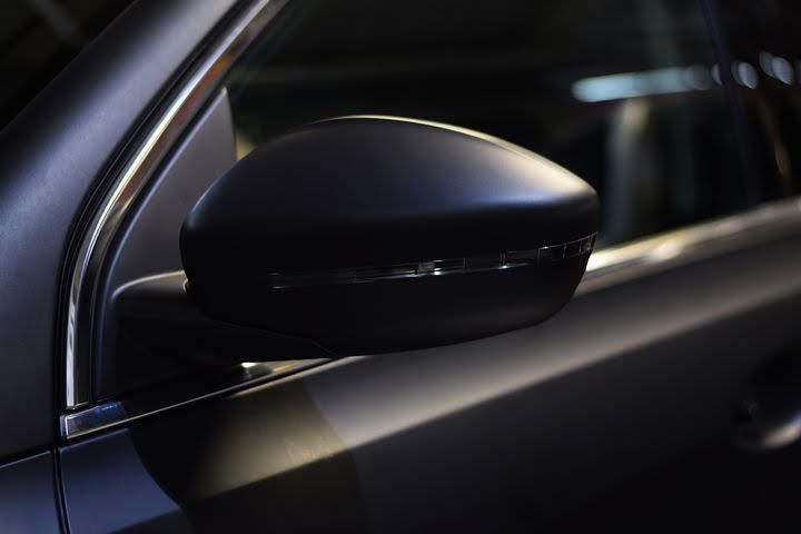 Close-up of a black car side mirror on a dark vehicle