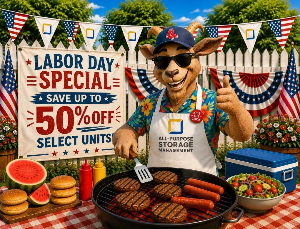 Labor Day grill sale sign with $50 off select units, burgers cooking, and a man in a hat at a barbecue display