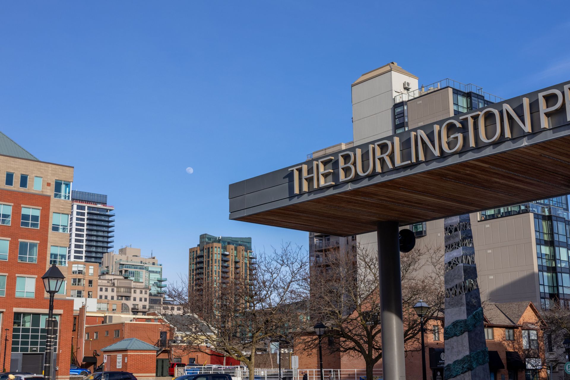 The Burlington Place sign over a city street with buildings under a clear blue sky