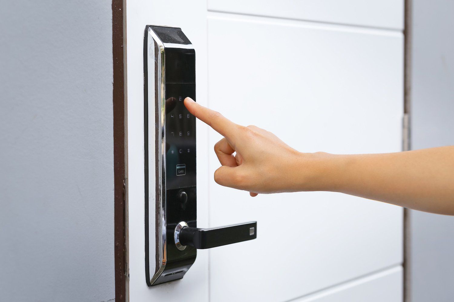 A person is pressing a button on a door lock.