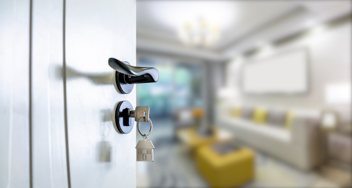 A door with a key in it is open to a living room.