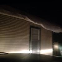 Dimly lit house exterior with light strip along the base and a closed door at night