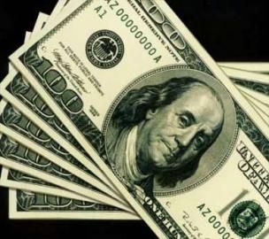 Stack of U.S. hundred-dollar bills fanned out on a black background