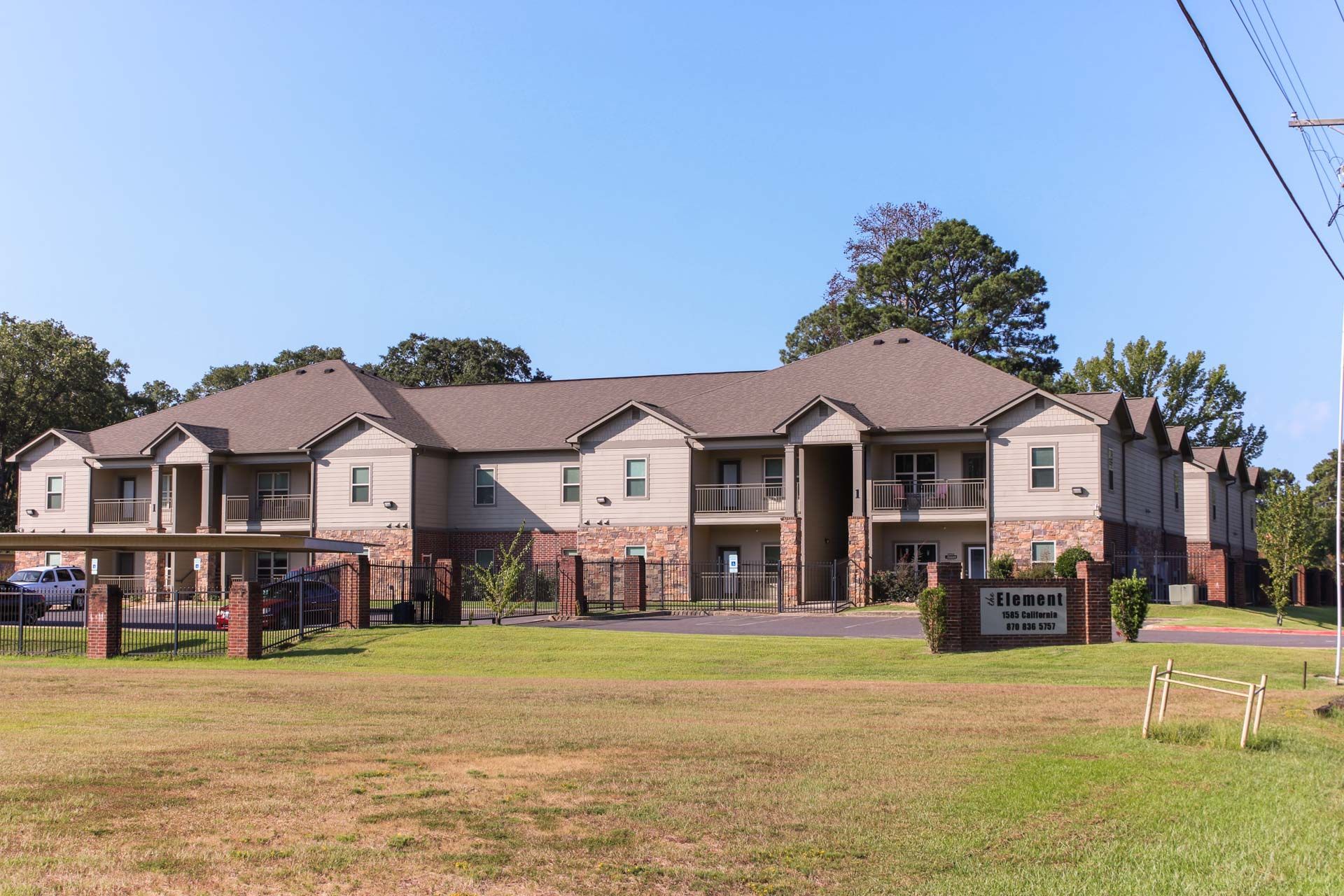 A large apartment building with a parking lot in front of it.