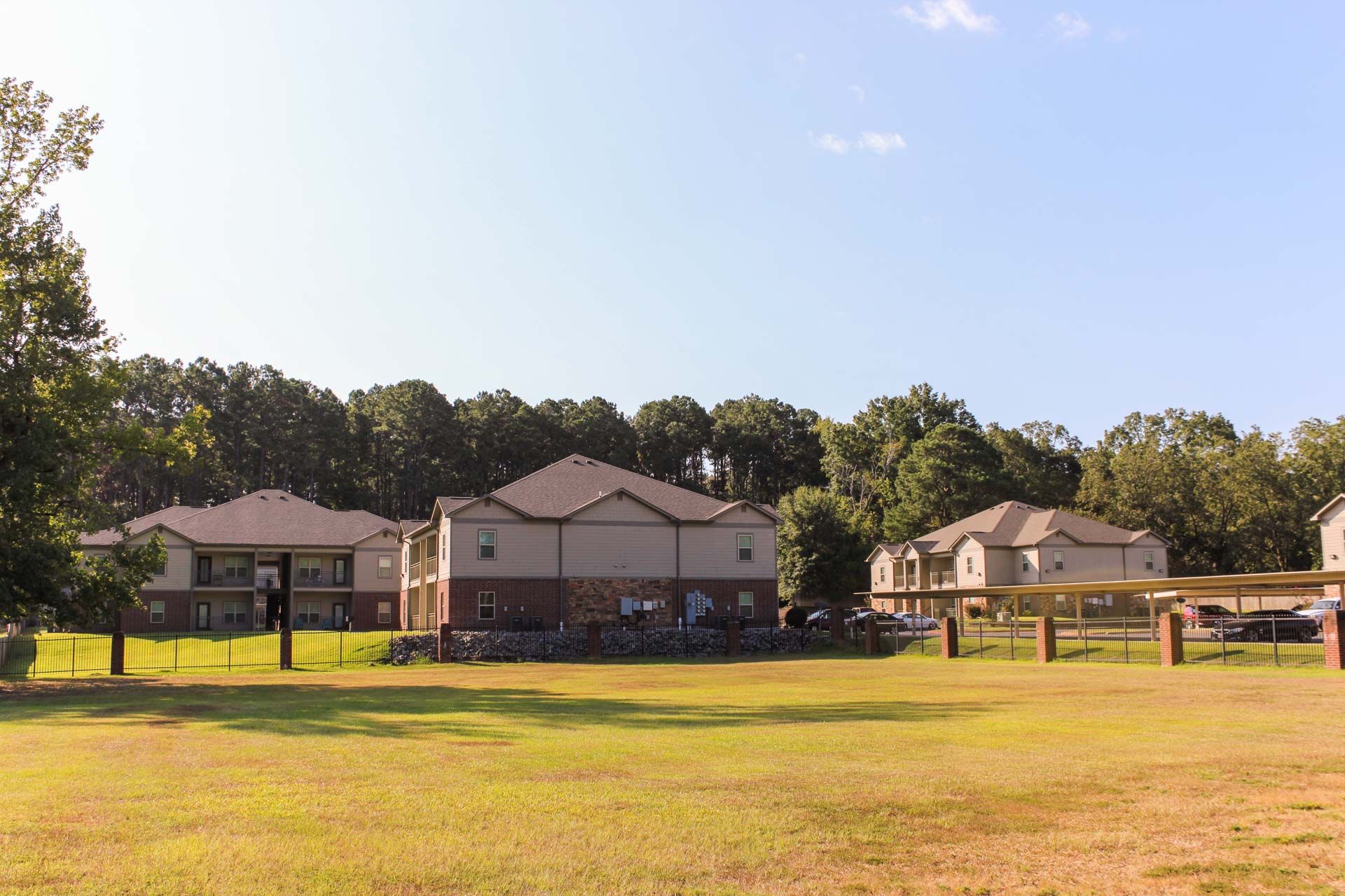A row of houses with a large grassy field in front of them