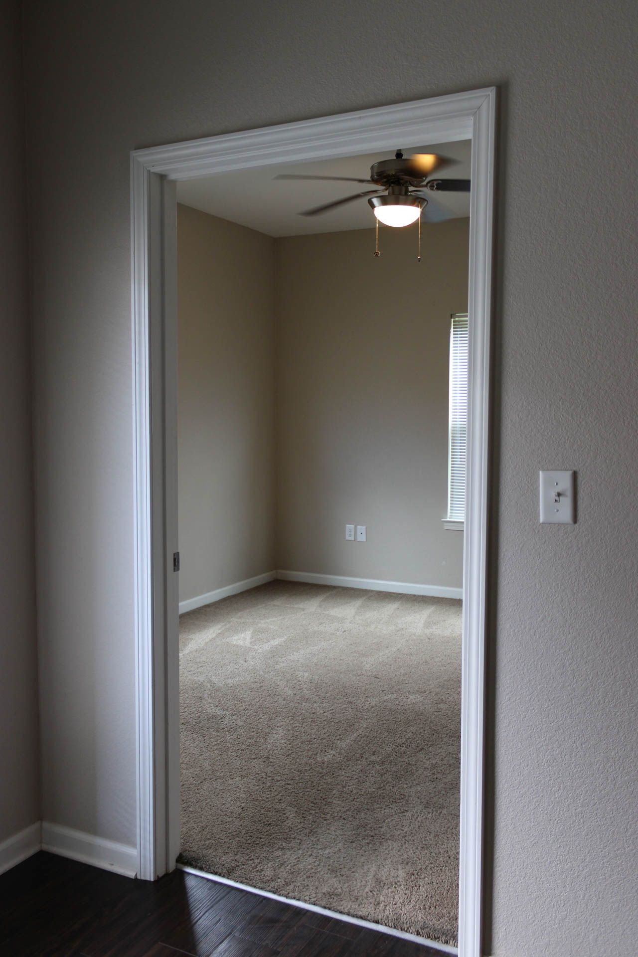 A doorway leading to a bedroom with a ceiling fan.