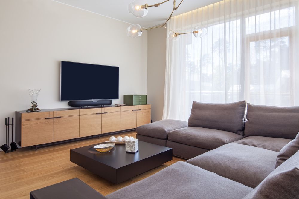 Modern Living Room With Grey Sectional, and Wooden TV Console — MATV Systems Australia Pty Ltd in Wickham, NSW