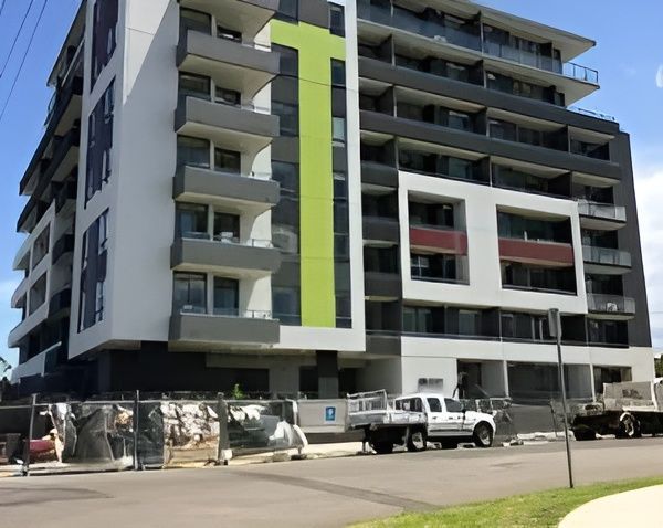 A Large Apartment Building with A Green Stripe on The Side — MATV Systems Australia Pty Ltd in Wickham, NSW