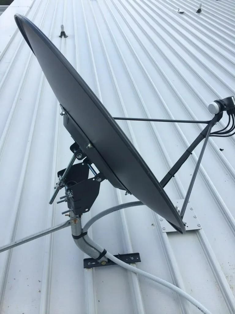 Satellite Dish Mounted on a White Corrugated Wall With Cables Attached — MATV Systems Australia Pty Ltd in Wickham, NSW