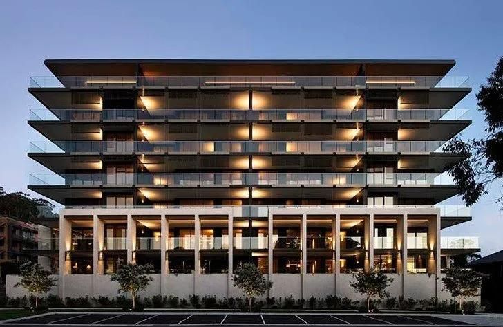 A Large Building with A Lot of Windows and Balconies Is Lit up At Night — MATV Systems Australia Pty Ltd in Wickham, NSW
