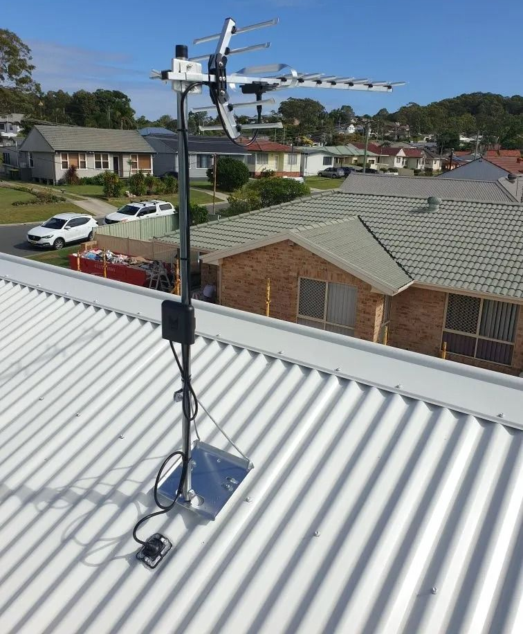 TV antenna mounted on a rooftop with suburban houses in the background — MATV Systems Australia Pty Ltd in Hunter Valley, NSW