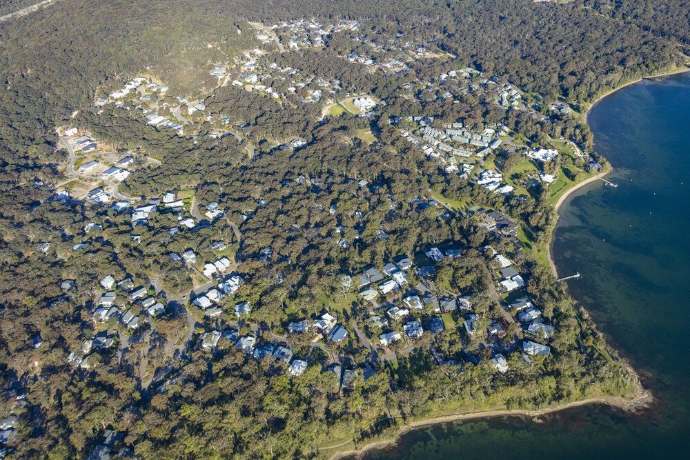 Aerial View of a Small Town Nestled in a Forest Along a Lake's Edge — MATV Systems Australia Pty Ltd in Wickham, NSW