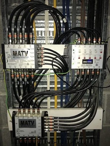 Electrical wiring panel with multiple black cables connected to MATV distribution boxes and connectors. — MATV Systems Australia Pty Ltd in Wickham, NSW