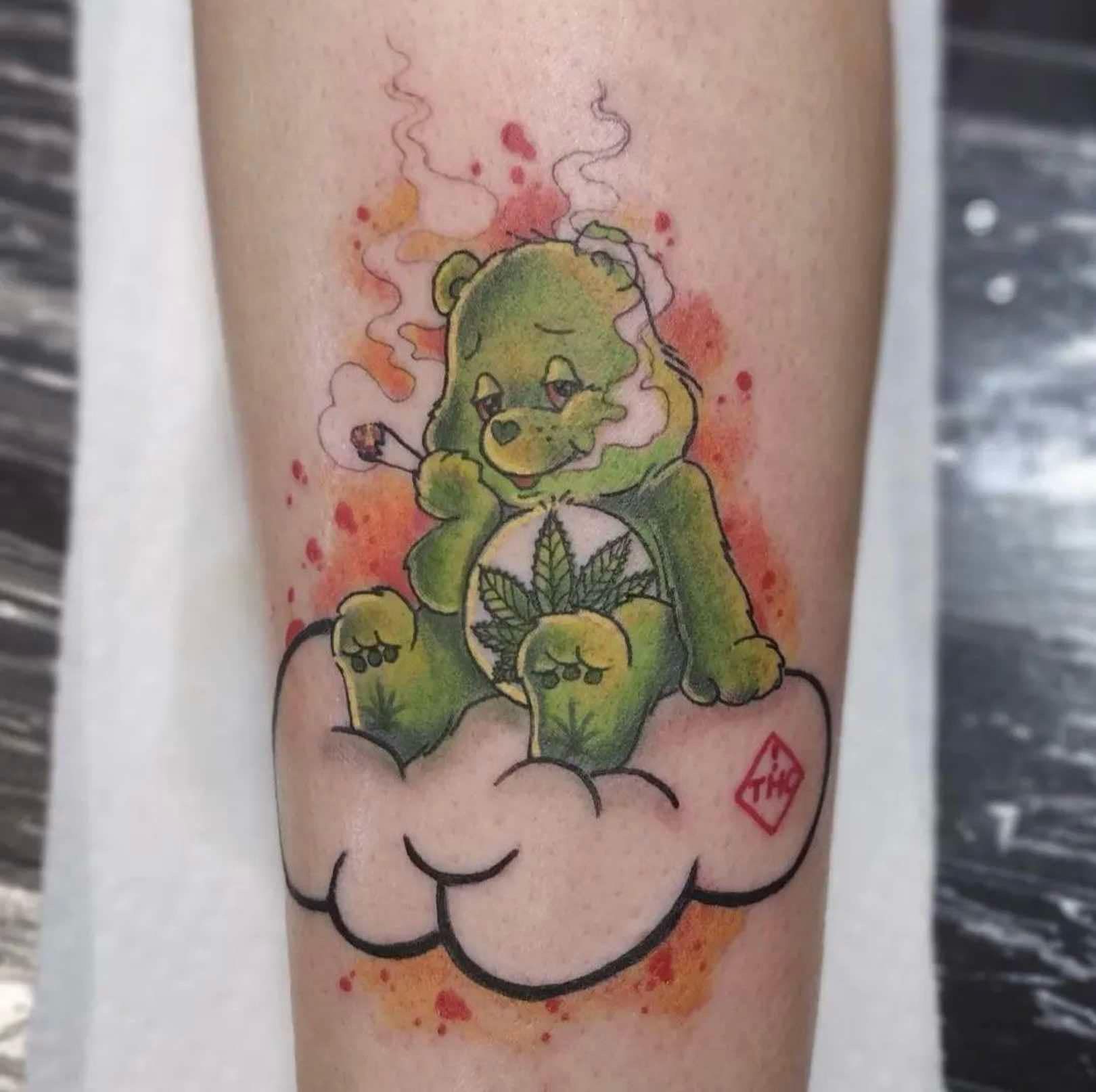 Green Care Bear smoking a joint, sitting on cloud, marijuana leaf on belly. Watercolor background.