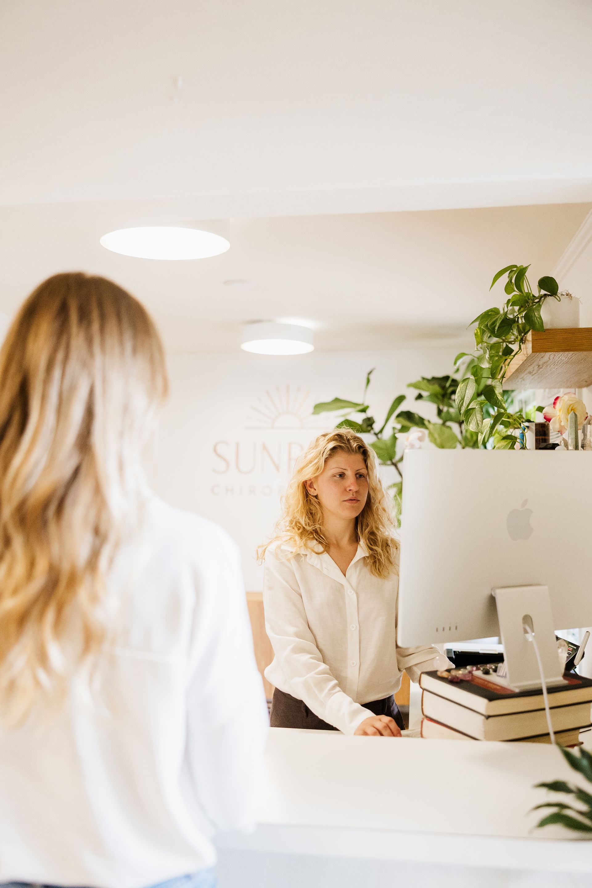 A patient stands at the desk to check in for their appointment.