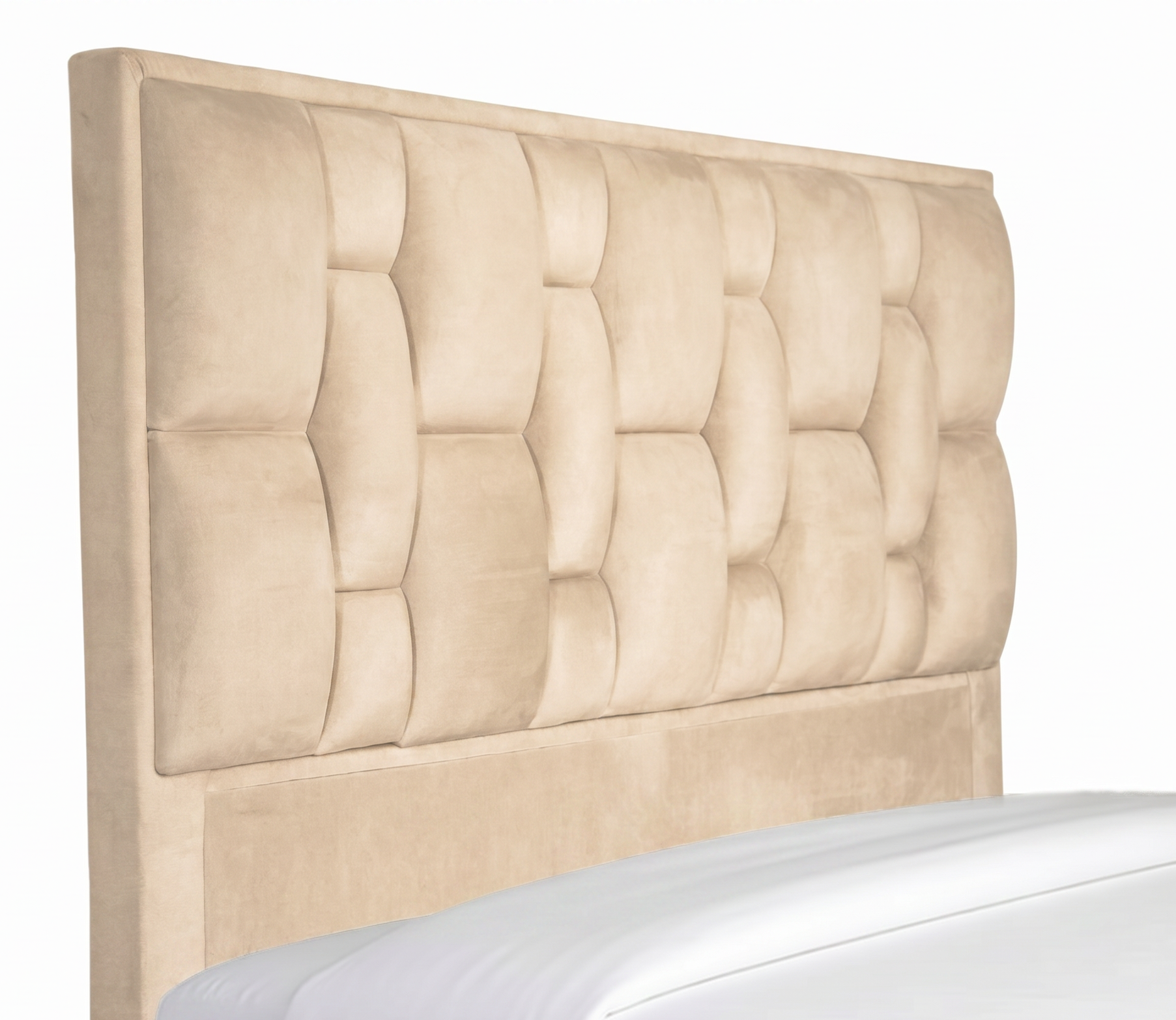 Cama tapizada en color beige con almohadas blancas en un dormitorio con iluminación tenue.