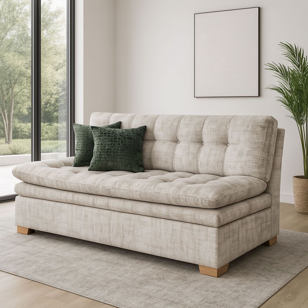 Sofá capitoné beige con cojines verdes en un luminoso salón moderno junto a una ventana.