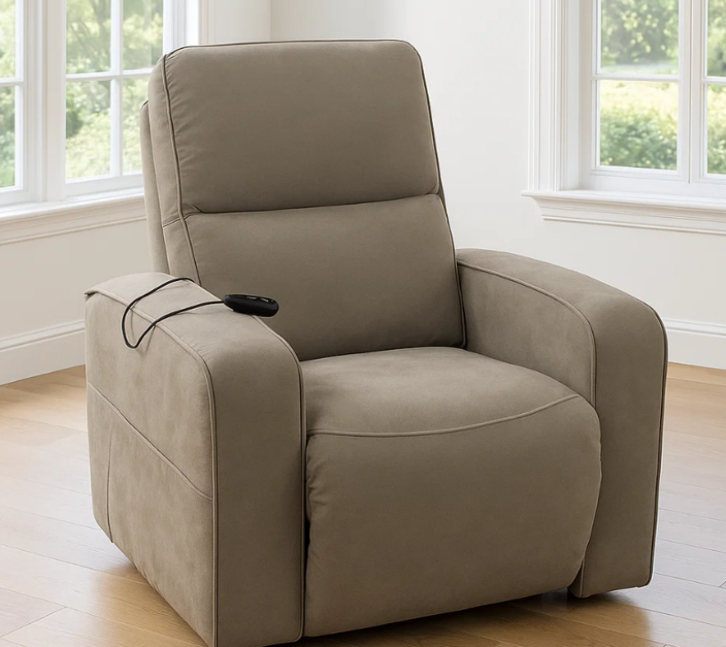 Sillón reclinable beige con controles laterales integrados en una habitación luminosa cerca de las ventanas.