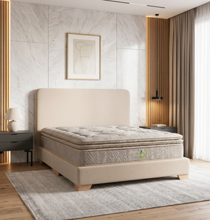 Cama tapizada en color beige neutro en un dormitorio moderno y luminoso con alfombra, cortinas y cuadros enmarcados en la pared.