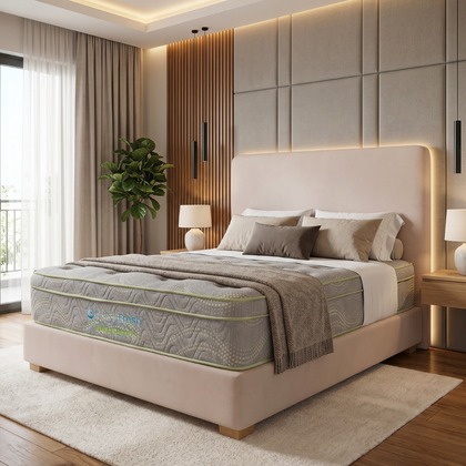Dormitorio moderno con cama tapizada en color beige, ropa de cama texturizada, iluminación cálida y una planta en maceta junto a la ventana.