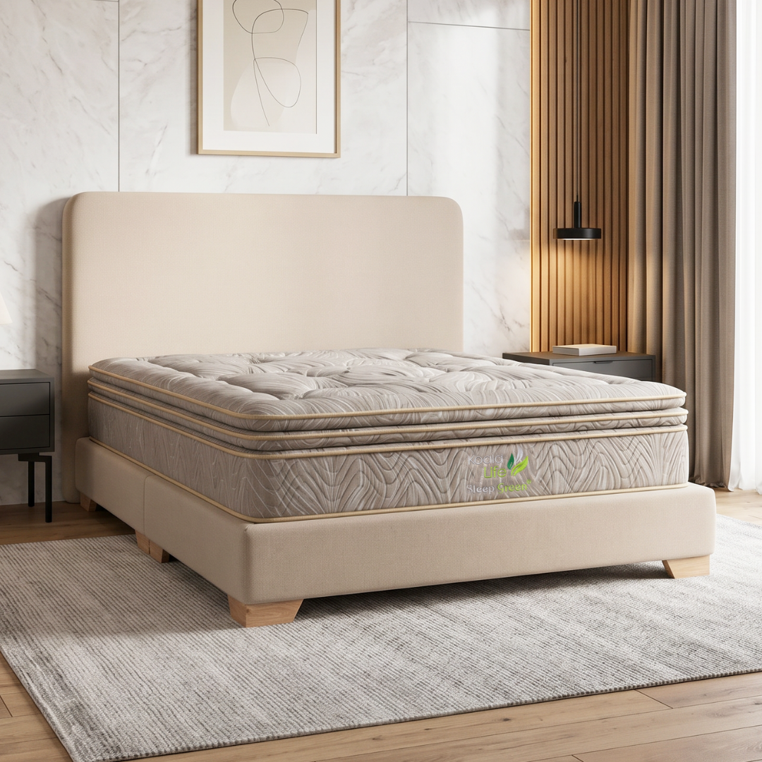 Cama tapizada en color beige con colchón en un dormitorio moderno y luminoso, junto a cortinas y una alfombra tejida.