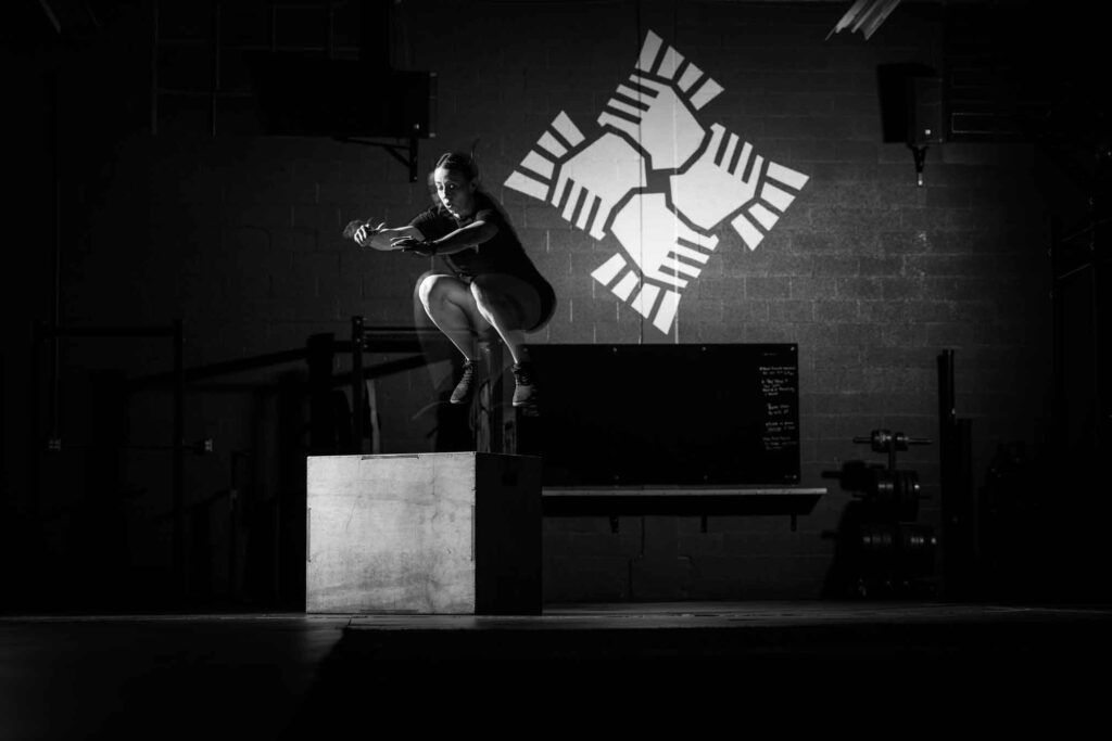 Black-and-white photo of a person doing a box jump at The Sect gym in south salt lake