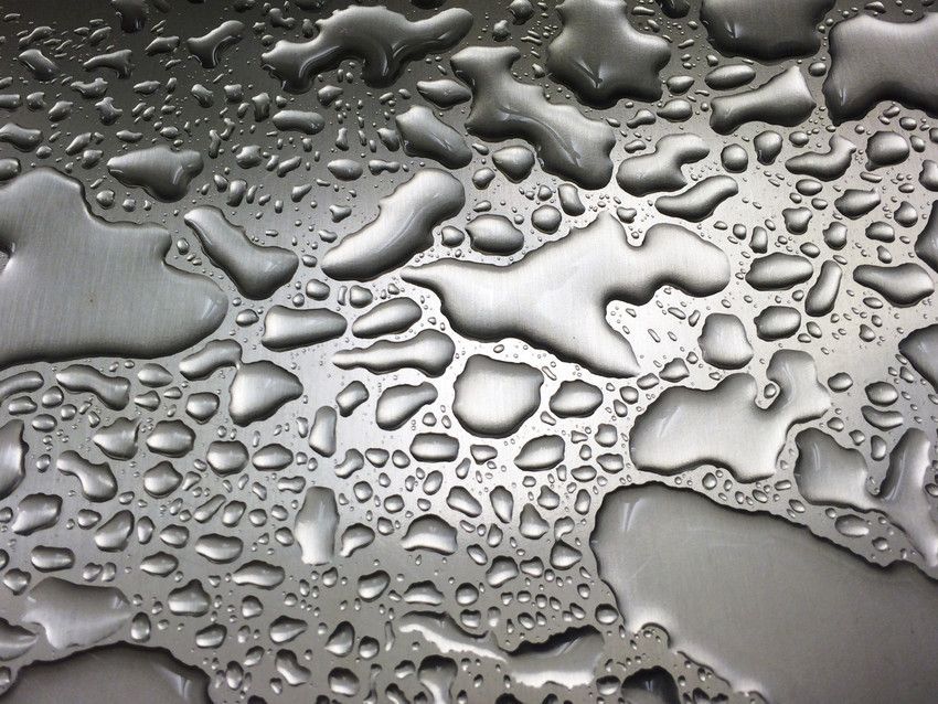 Water droplets in a brushed metal silver sink