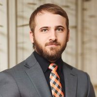 A man with a beard is wearing a suit and tie.