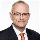 A man in a suit and tie is smiling for the camera.