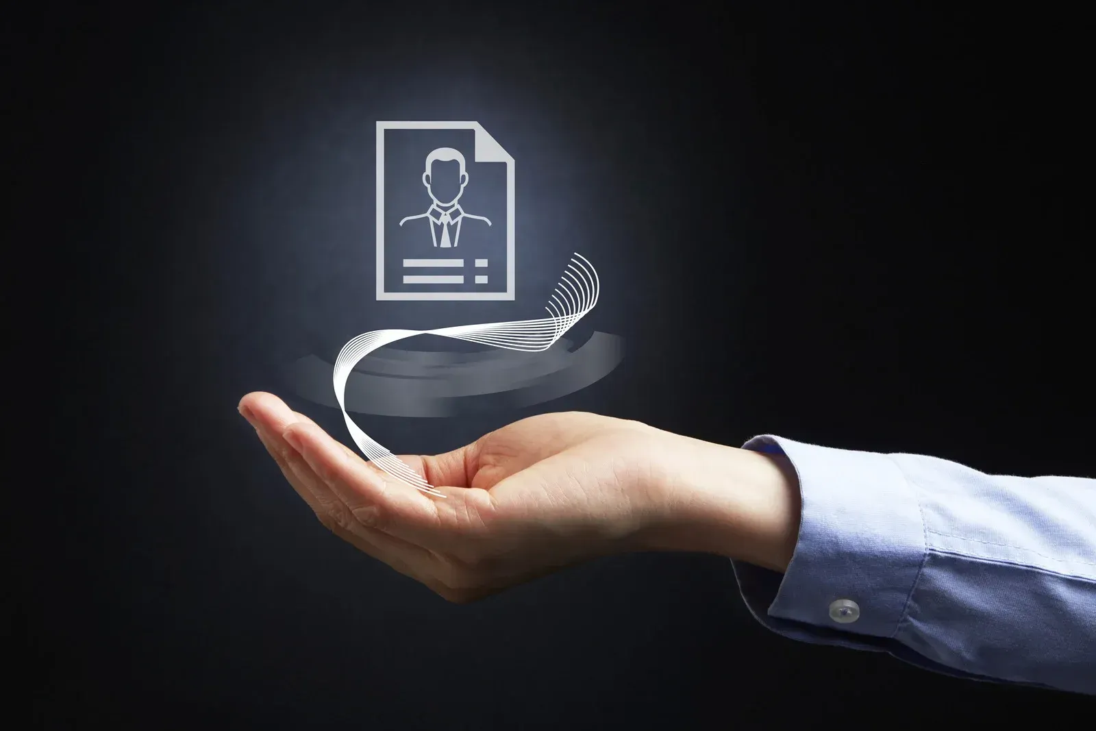 A hand is holding a picture of a person 's resume