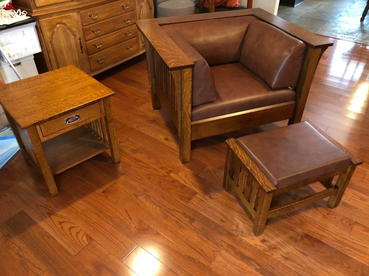 Wooden living room furniture set with armchair, side tables, and ottoman on hardwood floor