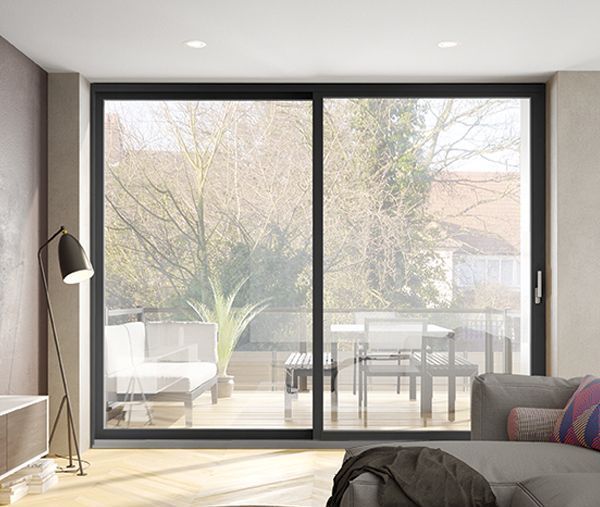 A living room with a couch , lamp , and sliding glass doors leading to a balcony.