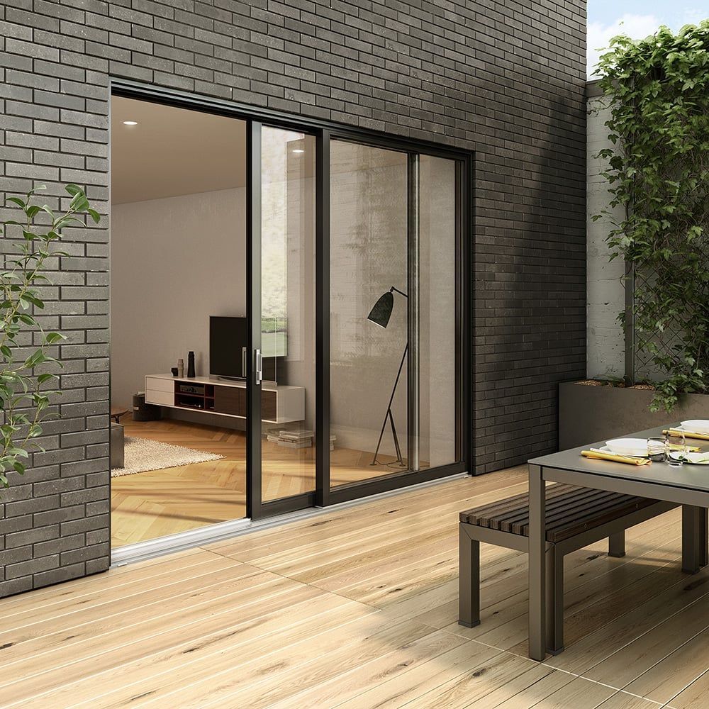 A patio with a table and benches and a sliding glass door