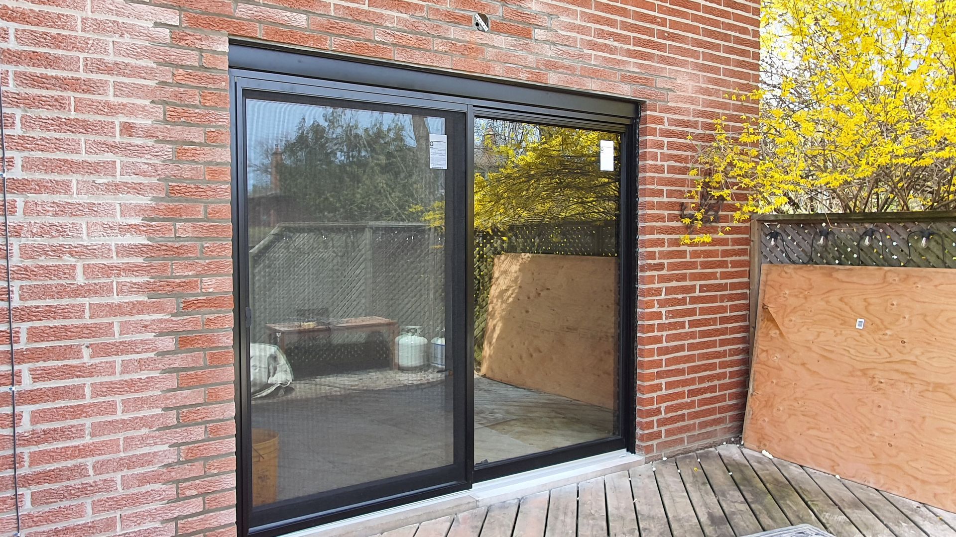 A brick building with a sliding glass door leading to a patio.